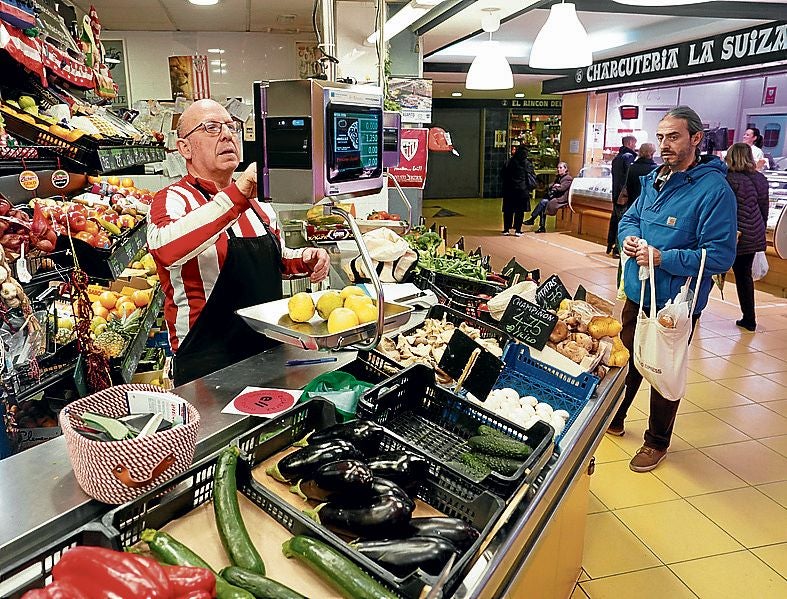 Un tendero calcula el precio de los limones en el mercado de Deusto.