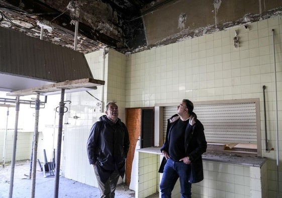 Los junteros Jorge Ibarrondo y Jonathan Romero observan la deteriorada cocina.