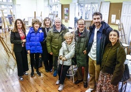 Angelines, en el centro, posa en su antigua clase con sus familiares y la directora.