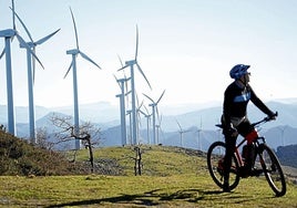 Un ciclista junto a los aerogeneradores instalados en el monte Oiz, similares a los que se proyectan en el Argalario.