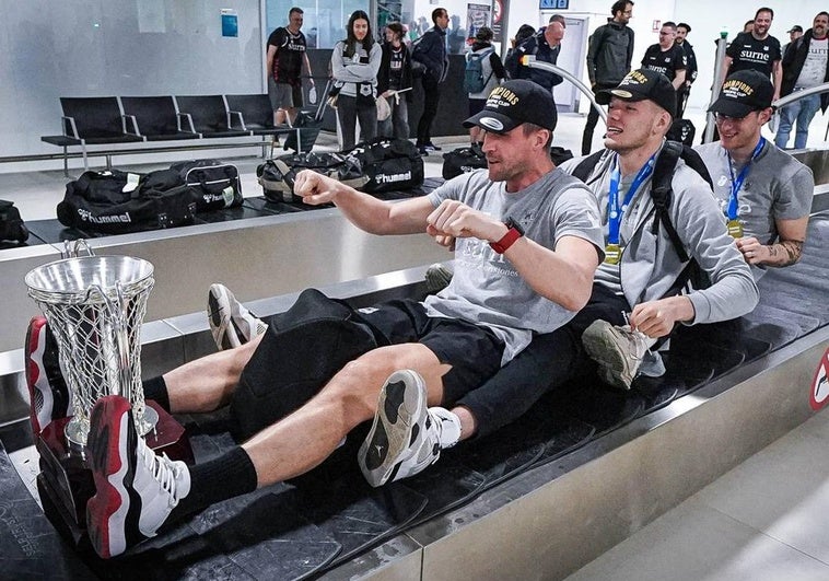Varios jugadores bromean con el trofeo a su llegada al aeropuerto de Vitoria esta madrugada.