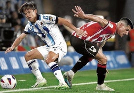 Take Kubo y Yuri Berchiche pelean por un balón en un derbi.