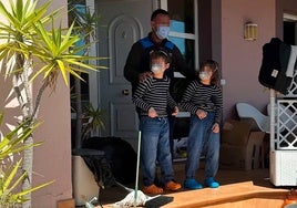 Dos de los menores salen al exterior del chalé en el que habían estado recluidos, el lunes junto a uno de los policías locales.