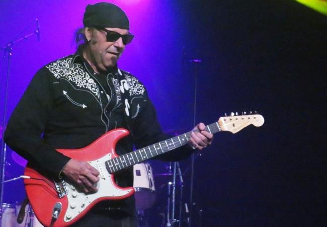 Con su camisa vaquera, de honky tonk.
