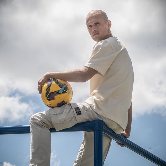 Jon Guridi posa con un balón subido a una de las vallas de uno de los campos de entrenamiento de Ibaia.