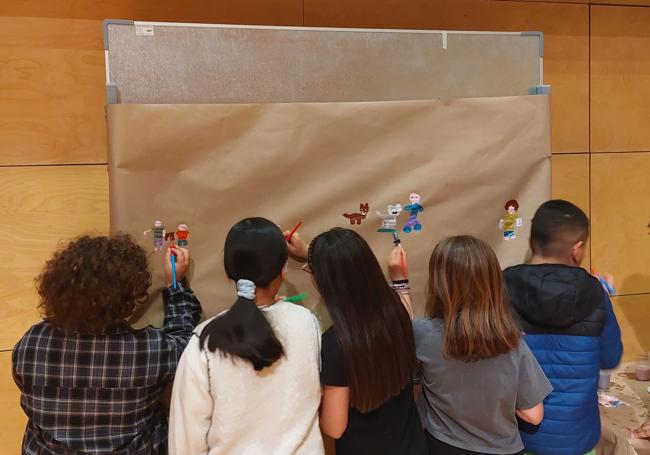 Varios alumnos elaborando un mural.
