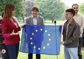 La europarlamentaria Idoia Mendia y el líder de las Juventudes Socialistas de Euskadi, Gabriel Arrúe, despliegan una bandera europea ante el secretario general del PSE, Eneko Andueza.