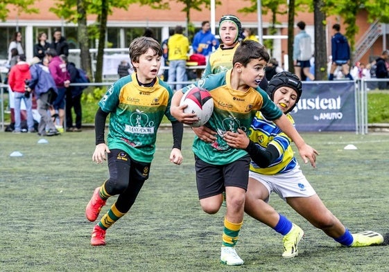 Un niño trata de placar a otro en un partido de la Araba Rugby Cup.
