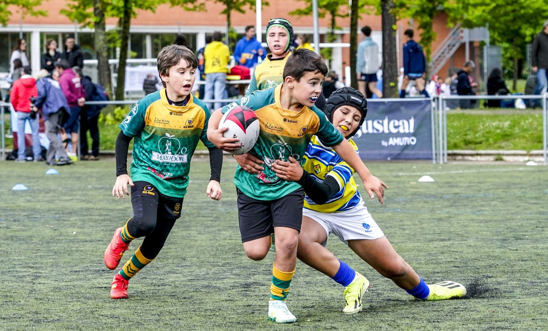 Un niño trata de placar a otro en un partido de la Araba Rugby Cup.