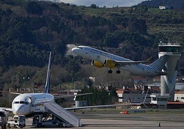 Un avión despega de Loiu en presencia de otro aparato en la plataforma.