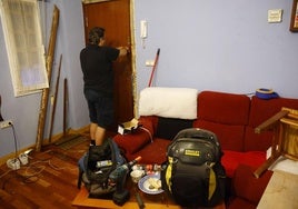 Un cerrajero trata de arreglar la puerta de una casa que había estado okupada.