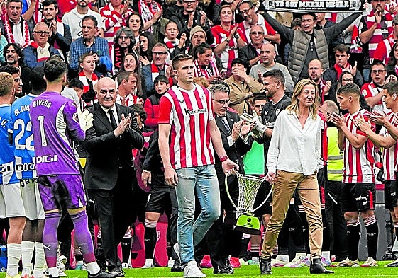 Xavi Rabaseda e Isabel Iturbe, portando la copa de campeones de la Europe Cup. encabezan la salida del Surne Bilbao Basket al centro de San Mamés.