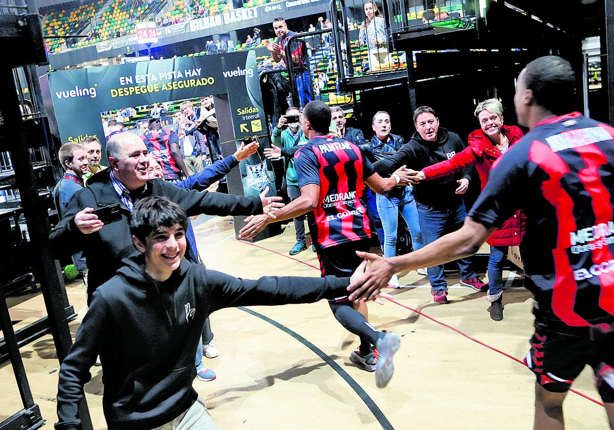 Los ocho suscriptores chocan las manos con los jugadores del Bilbao Basket poco antes de arrancar el partido contra el Coruña.