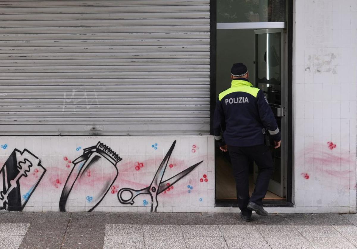 Un policía local entra en la barbería precintada.