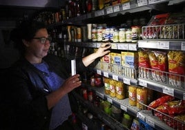 Una clienta ilumina las estanterías de un supermercado con su móvil. durante el apagón.
