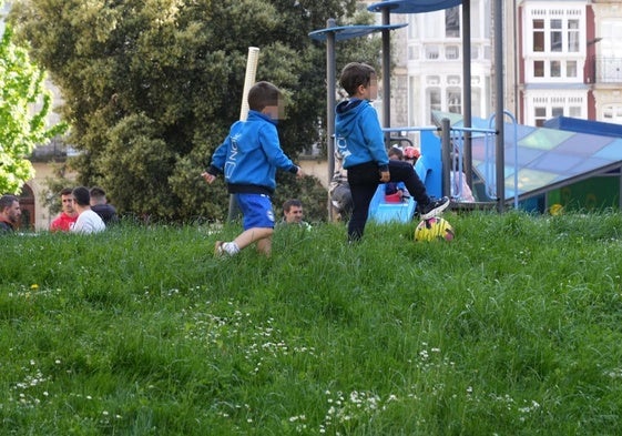 Unos niños intentan jugar al fútbol en los jardines de la plaza Amárica.