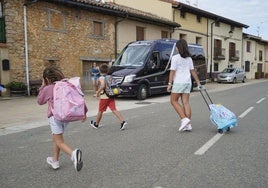 Unos niños de Lagrán se dirigen al microbús que les lleva al colegio en Campezo.