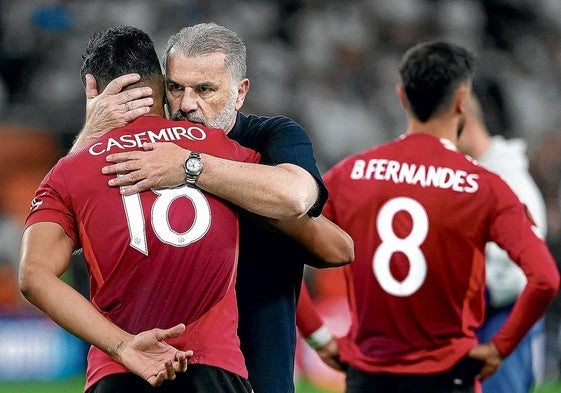 El entrenador del Tottenham, Angelo Postecoglou, consuela a Casemiro, con Bruno Fernandes en segundo plano.