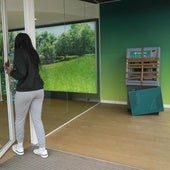 Una clienta accede al interior de la entidad. Al fondo, el cajero atacado por los dos ladrones.