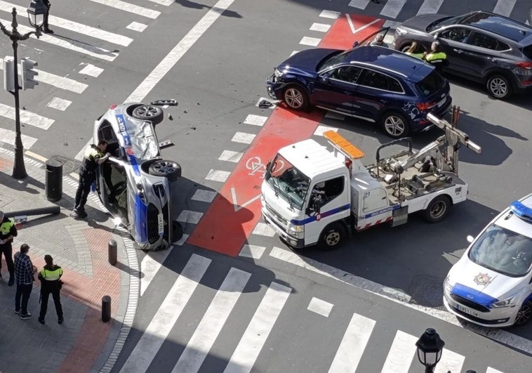 El coche patrulla quedó volcado en la confluencia de Alameda de Urquijo con Elcano tras chocar con un 'Audi'.