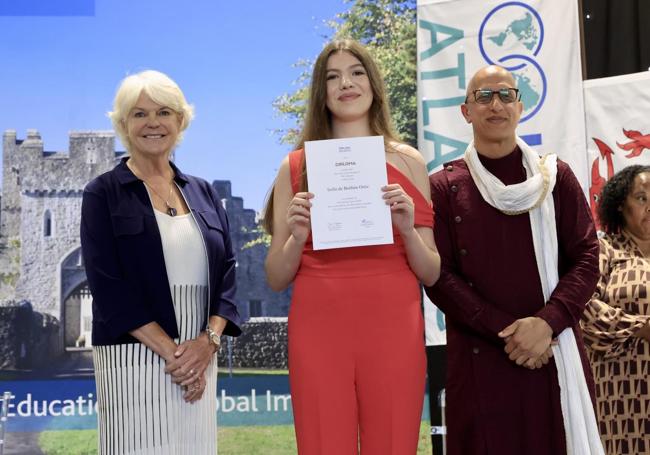 La innfanta Sofía recibe su diploma de graduada en Bachillerato Internacional de manos de Naheed Bardai, director del UWC College de Gales y Jill Longson, presidenta del Comité de Gobierno del UWC Atlantic College y antigua alumna de 1981, durante la ceremonia de graduación en el UWC Atlantic College de Gales, donde concluye el Bachillerato Internacional.