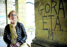 Carmen Hernández, viuda de Jesús Mari Pedrosa, retratada esta semana en los soportales de la iglesia de Santa Ana en Durango, junto a una pintada de apoyo a ETA.