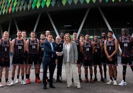 Xabier Sagredo, presidente ejecutivo de BBK, e Isabel Iturbe, presidenta del Bilbao Basket, se estrechan la mano frente a la plantilla, con Miribilla a sus espaldas.