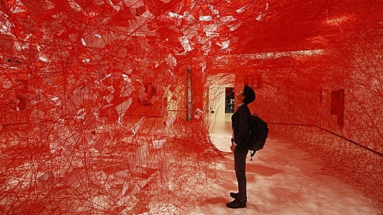 La japonesa Chiharu Shiota invita a su casa edificada con telarañas rojas en Azkuna Zentroa