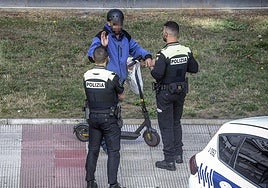 Dos agentes llaman la atención a un patinetero por circular por la acera.
