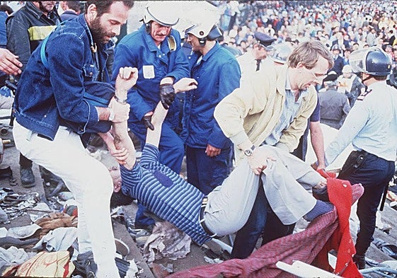 Voluntarios y agentes retiran a los fallecidos en la tragedia de Heysel.