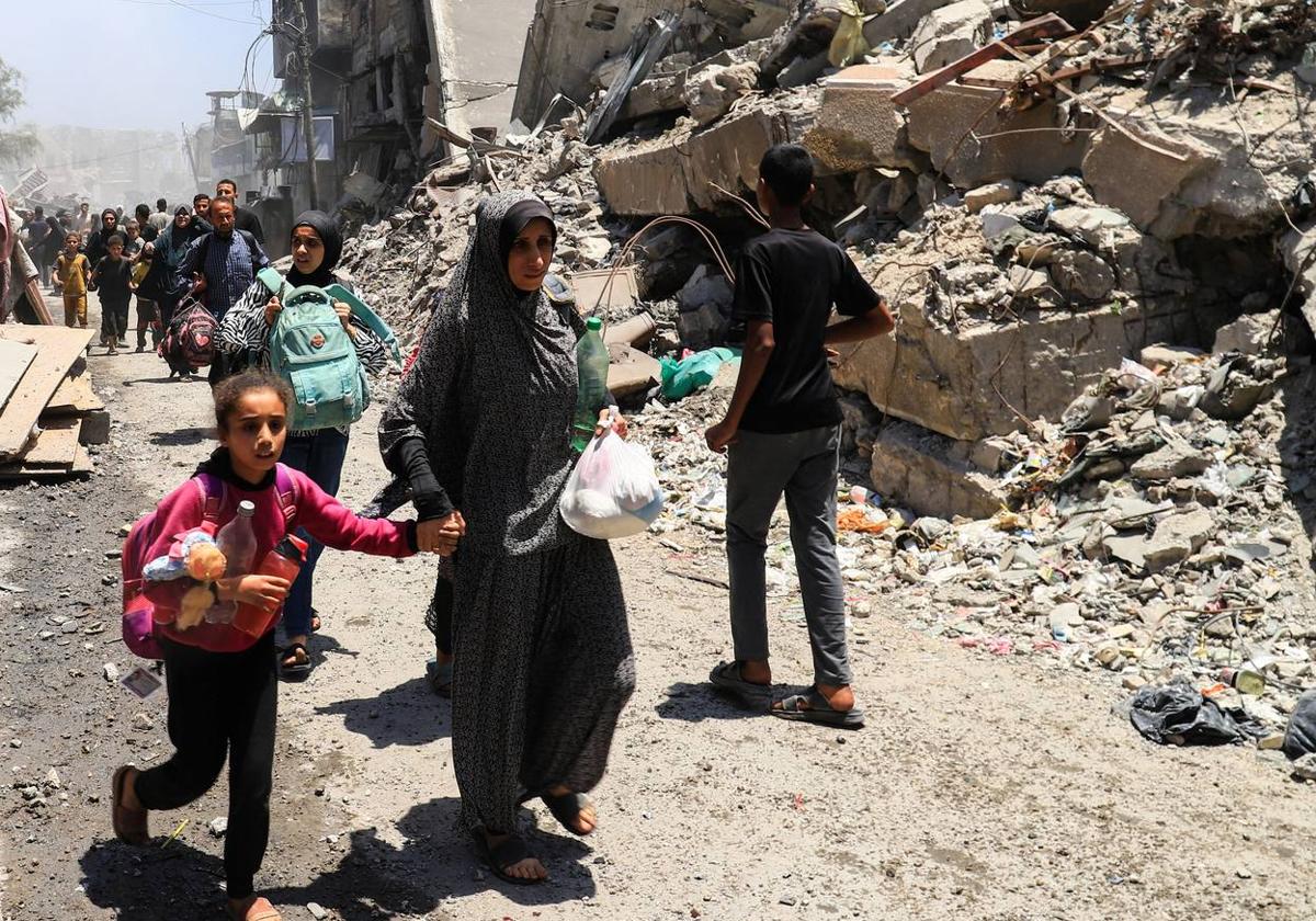 Palestinos evacuados tras un ataque israelí contra una casa en la ciudad de Gaza.