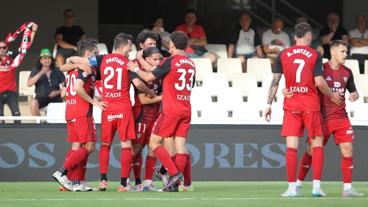 Álex Calvo recibe la felicitación de sus compañeros tras marcar el último gol de la temporada.