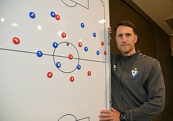 El preparador donostiarra posa junto a la pizarra en la que expone sus ideas de juego.