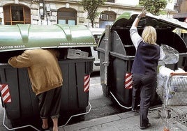 Un hombre recoge alimentos de un contenedor de basuras.