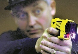 Un agente utiliza una de estas pistolas que lanzan una descarga eléctica.