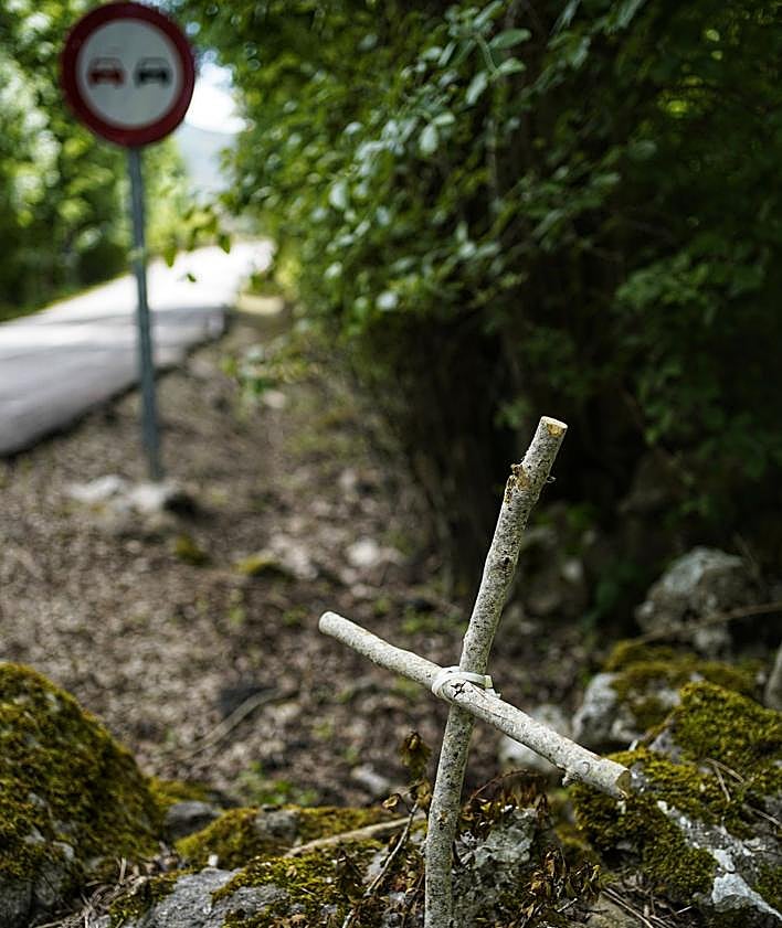 Imagen secundaria 2 - Roberto Ortiz, en el punto de Lunada donde se despeñaron los jóvenes madrileños. Restos del vehículo accidentado en los 90. Cruz hecha con palos en recuerdo del motorista alemán, junto a la señal contra la que se estrelló. 