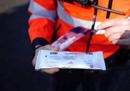 Imagen de un ertzaina con uno de los test de drogas que se usan en los controles.