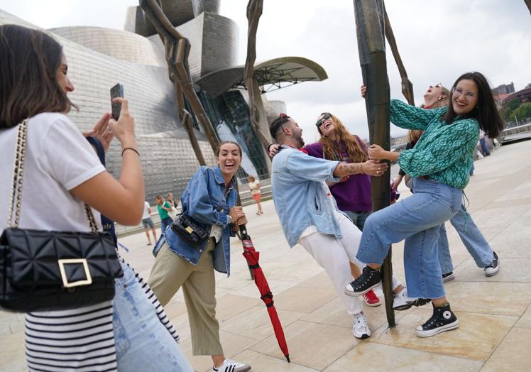 Turistas se fotografían junto a la araña del Guggenheim.