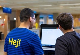 Un trabajador de Ikea atiende a un cliente.