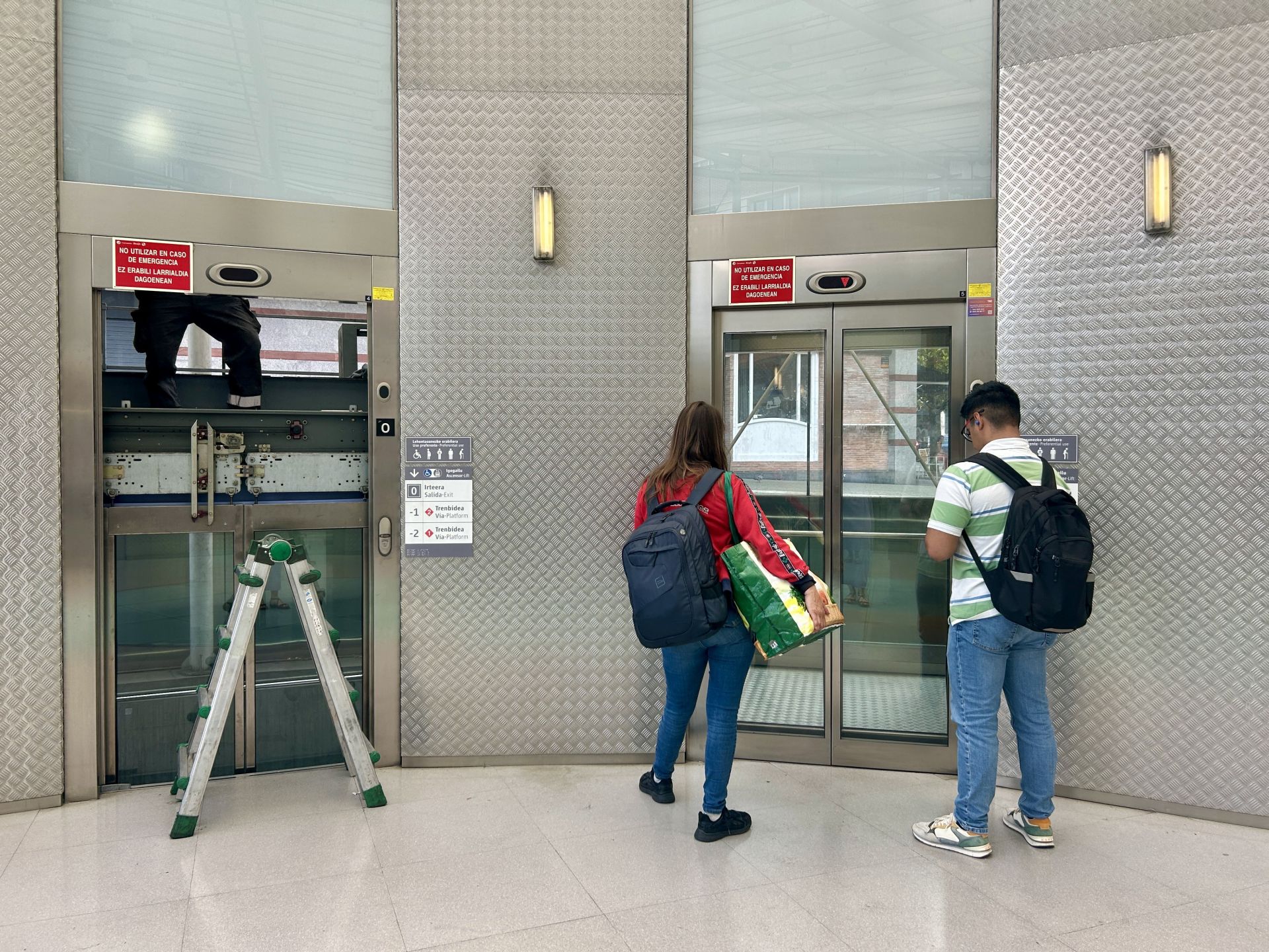 Varios usuarios esperan al único ascensor en funcionamiento en la estación de Renfe en Miribilla.
