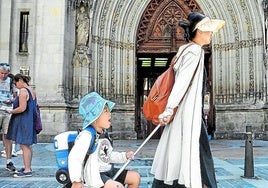 Turistas asiáticos pasan delante de la Catedral de Santiago.