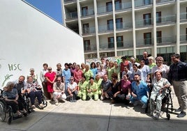 Los usuarios de la residencia se sacaron una foto de familia junto con los cuidadores y el mural realizado.