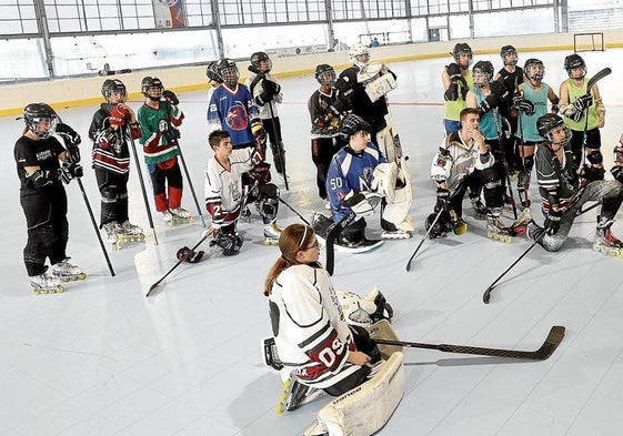 Jugadores de las categorías inferiores del Metropolitano HCatienden a un entrenador en la pista del polideportivo municipal de Zorroza.