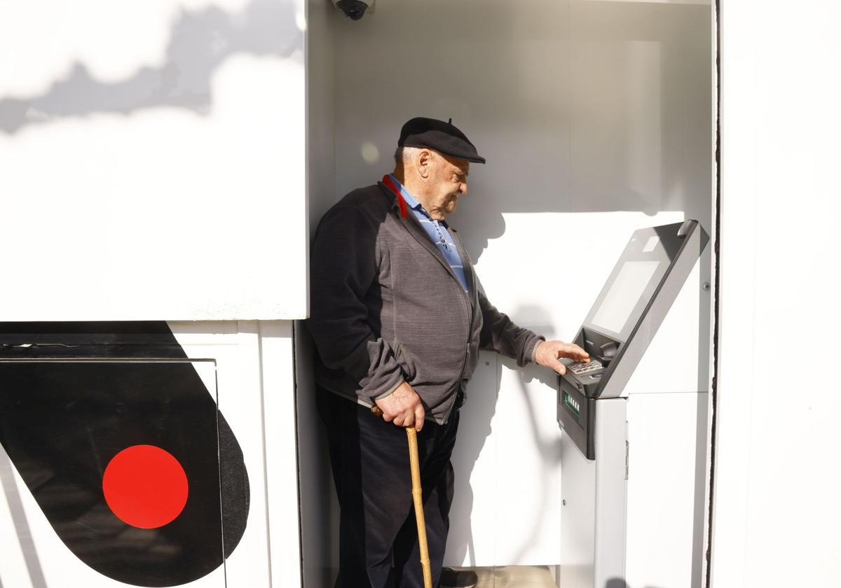 Una persona de avanzad edad utiliza el cajero automático de una oficina móvil bancaria, en un pueblo de Álava.