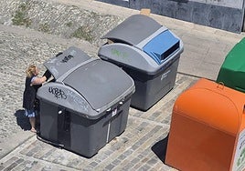 Una mujer deposita la basura en uno de los contenedores de Goiko plaza, en Bermeo.