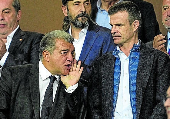 Joan Laporta se tapa la boca para dirigirse a alguien en el palco de Montjuic en presencia de Jon Uriarte, en un partido en octubre de 2023.