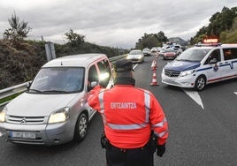 Un ertzaina de la unidad de Tráfico da el alto a un vehículo durante n control en una carretera vasca.