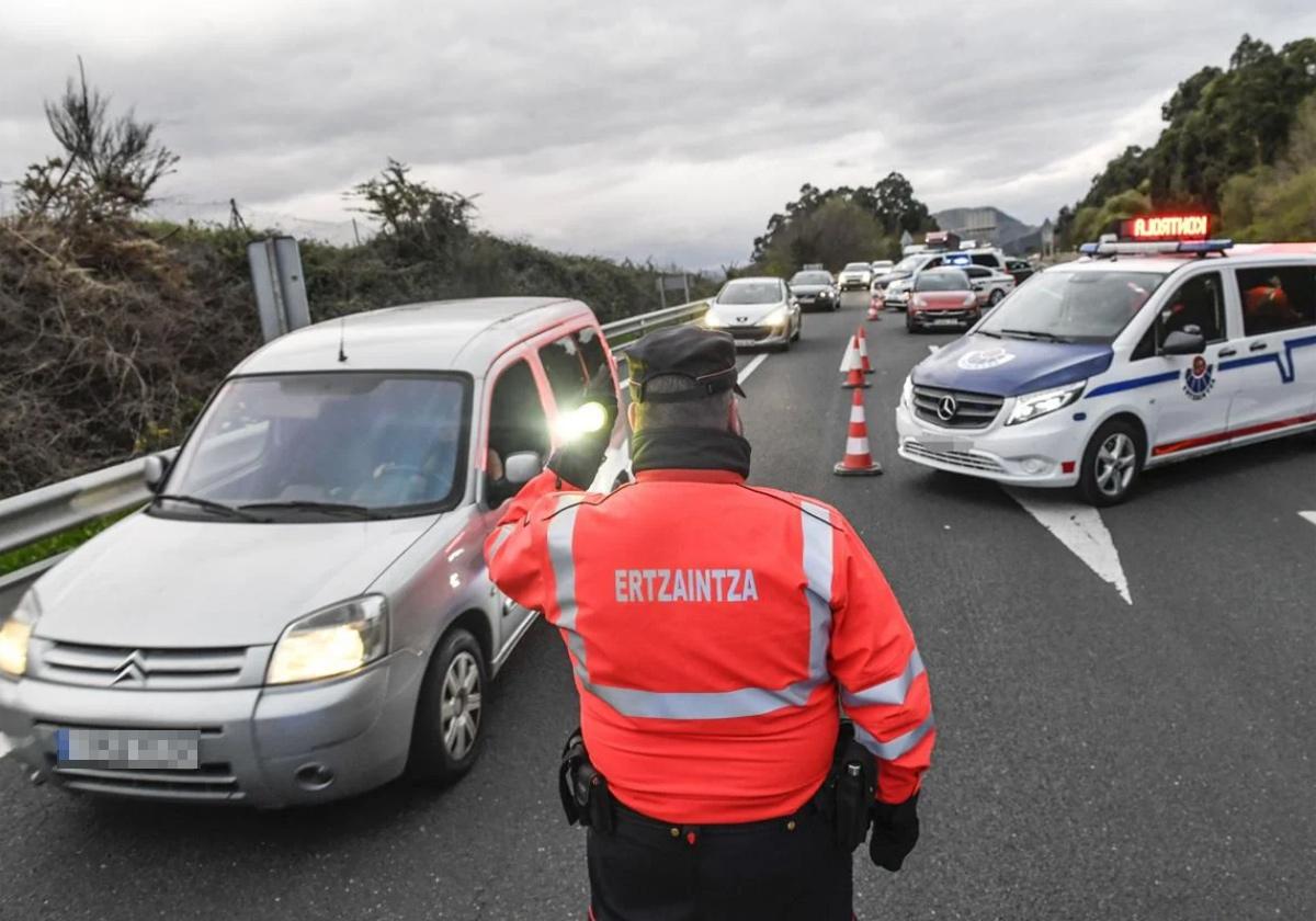 Un ertzaina de la unidad de Tráfico da el alto a un vehículo durante n control en una carretera vasca.
