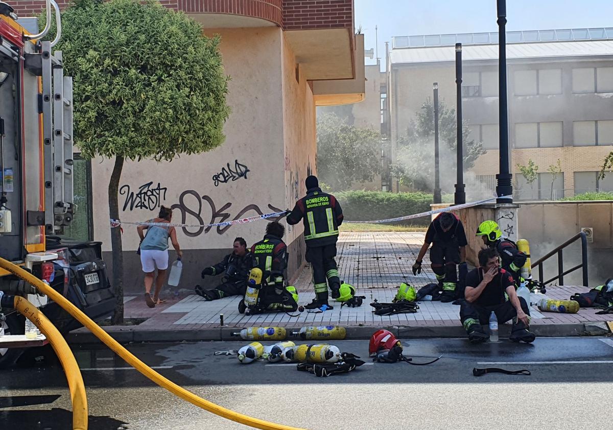 Imagen principal - Los bomberos tenían que descansar dadas las adversas condiciones del incendio que se percibía desde diferentes puntos de la ciudad.