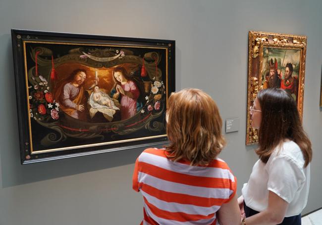 Dos visitantes contemplan 'Sagrada Familia' (1660) de Josefa de Óbidos.